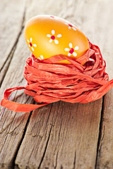 Easter background. Macro shot of painted egg and ribbon decoration on old wooden texture