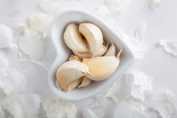 studio shot of garlic in heart shaped bowl