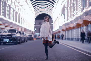 portrait of a woman white sweater winter, seasonal outside city walk in the evening city