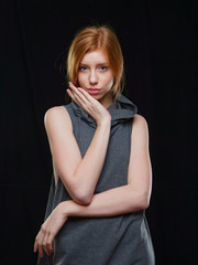 Fototapeta premium young girl with long red hair on a black background