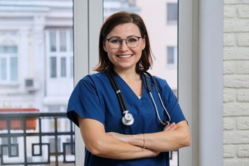 Portrait of mature nurse woman in blue uniform with stethoscope