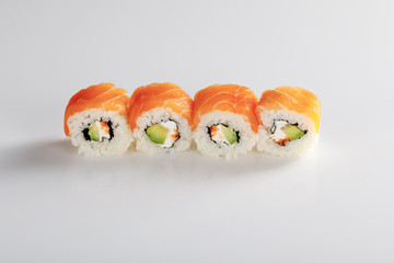 delicious Philadelphia sushi with avocado, creamy cheese, salmon and masago caviar on white background