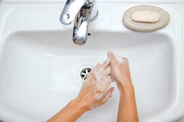 Hygiene concept. Washing hands with soap under the faucet with water