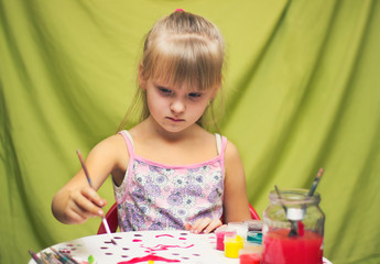 a kid, a girl spends time having fun with gouache paint