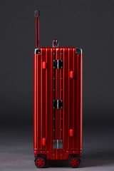 The red suitcase is on a black background,