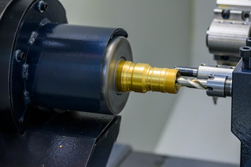 The CNC lathe machine bore cutting at the brass shaft pipe. The brass water pipe connector...