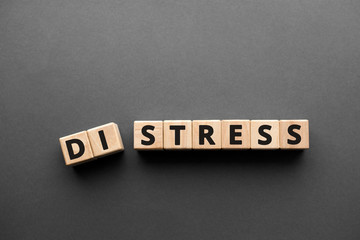 Distress Stress  - words from wooden blocks with letters, distress to stress concept, top view gray...