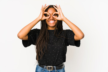 Young african american woman isolated on white background showing okay sign over eyes