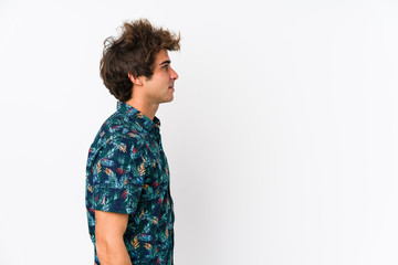 Young caucasian man wearing a flower t-shirt isolated gazing left, sideways pose.