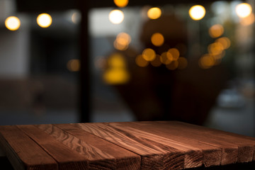 Empty brown wooden table and blur background of abstract of resturant lights people enjoy eating...