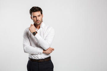 Image of young caucasian businessman posing and looking aside