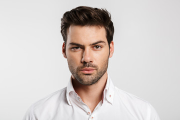 Image of young caucasian businessman posing and looking at camera
