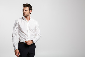 Image of young caucasian businessman posing and looking aside