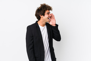 Young caucasian business man against a white background isolated shouting and holding palm near...