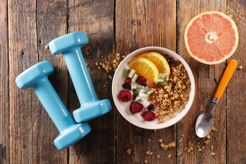 muesli, dairy and fruit- dumbbell- fitness food concept