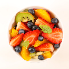 fruit salad with strawberry, blueberry, orange, banana and kiwi on white background