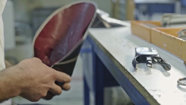 Craftsman gluing and stiching all parts of a upper part of a shoe together. 