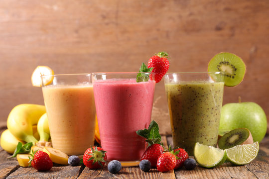 glasses of fruit smoothies with berries fruits, banana, apple