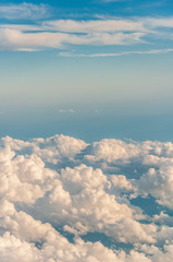sky seen from an airplane window with lots of clouds and contrasting colors