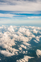 sky seen from an airplane window with lots of clouds and contrasting colors