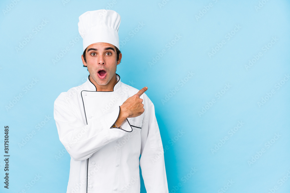 Canvas Prints young cook man isolated pointing to the side