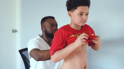 A black African American paediatrician and his young mixed patient. A handsome African American teen at the clinic for medical checkup.