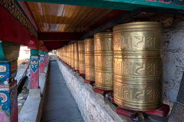 Rows of ancient traditional golden wheels of tibetan temple