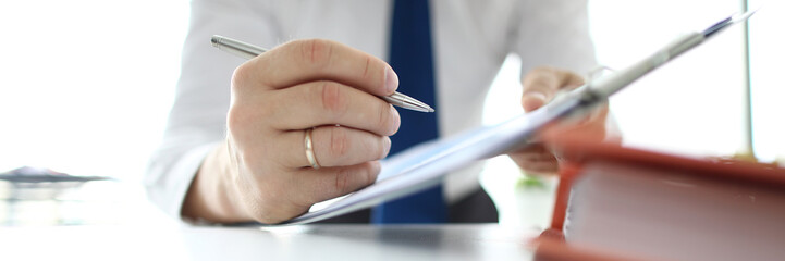 Focus on banking businessman hands pointing with metallic writing pen at business document in modern office. Businessman analyze marketing data. Audit concept