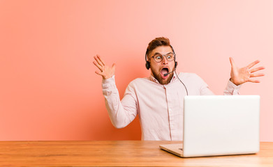 Young man working in a call center celebrating a victory or success