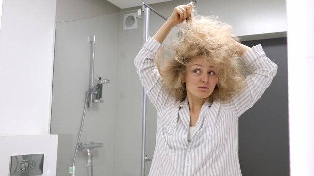 Crazy Tired Sleepy Woman Doing Her Tangled Hair In Bathroom.