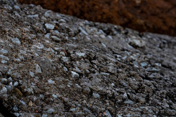Piles of boulders spread all over the coast; Macro texture of granite and sand