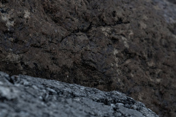 Piles of boulders spread all over the coast; Macro texture of granite and sand