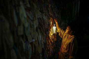 Woman looking at the prayer blocks with lantern