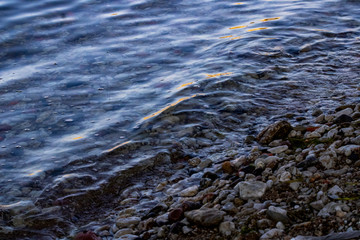 Small beach by the coast covered with multiple stones and sand