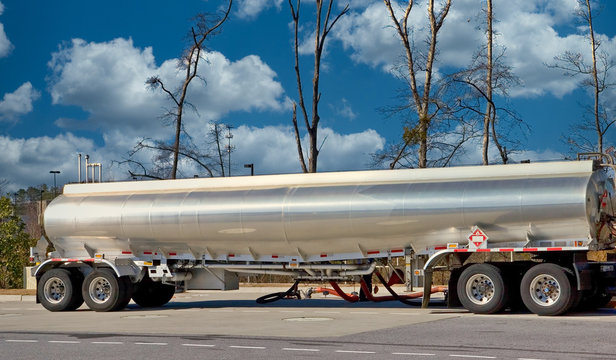 A tanker truck dispensing fuel at a gasoline station