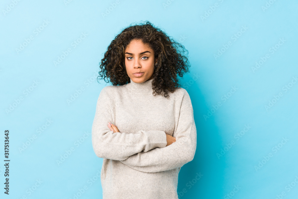 Wall mural Young african american curly hair woman frowning face in displeasure, keeps arms folded. - Wall murals