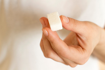 young woman holding white sugar cube