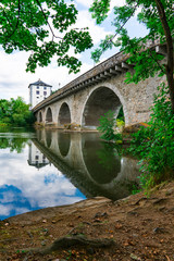 Fototapeta na wymiar Bridge called Alte Lahnbrucke, with reflection in river. In Limburg an der Lahn, Germany 
