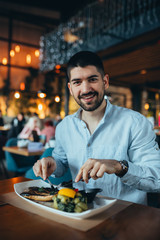 young man eating lunch in restaurant