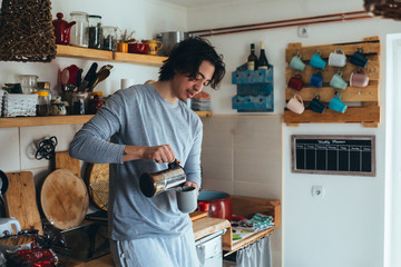 young man drinking coffee in his kitchen