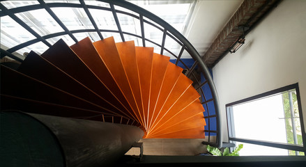 Top view of rounded wooden mix steel stairs look down to the floor.