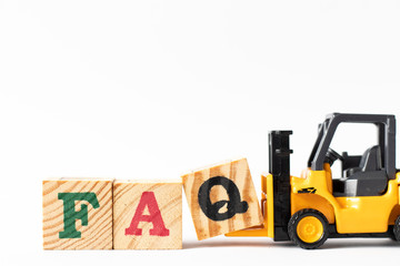 Toy forklift hold wood letter block Q to complete word  FAQ (Abbreviation of Frequently Asked Questions) on white background
