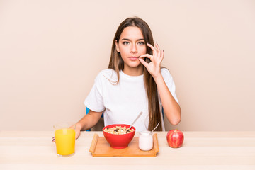 Young caucasian woman having a breakfast isolated with fingers on lips keeping a secret.