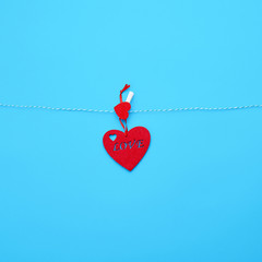 one red felt heart hanging on a white rope and fastened with a clothespin