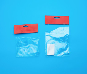two transparent torn plastic bags with paper red top for packaging goods