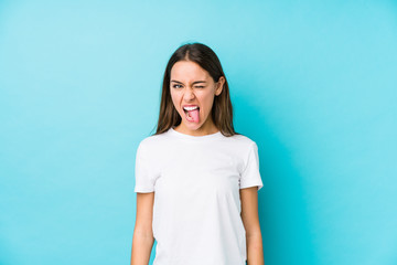 Young caucasian woman  isolated funny and friendly sticking out tongue.