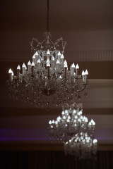Large crystal chandeliers with lots of lights in a restaurant