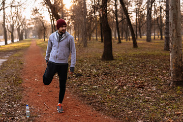 handsome young man jogging outdoors in city park