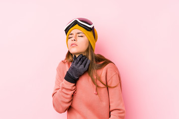 Young caucasian woman wearing a ski clothes isolated suffers pain in throat due a virus or infection.