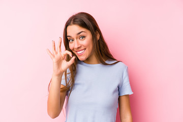 Young caucasian woman wearing a ski clothes isolated cheerful and confident showing ok gesture.